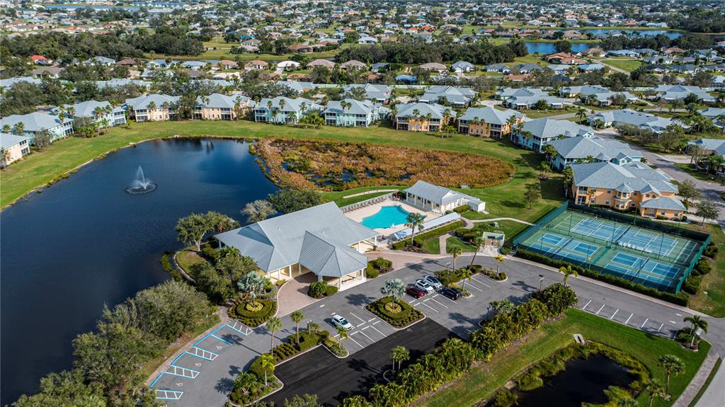 An aerial view shows a community clubhouse with a pool, tennis courts, and a lake — 25601 HERITAGE LAKE BOULEVARD UNIT 46, PUNTA GORDA, FL