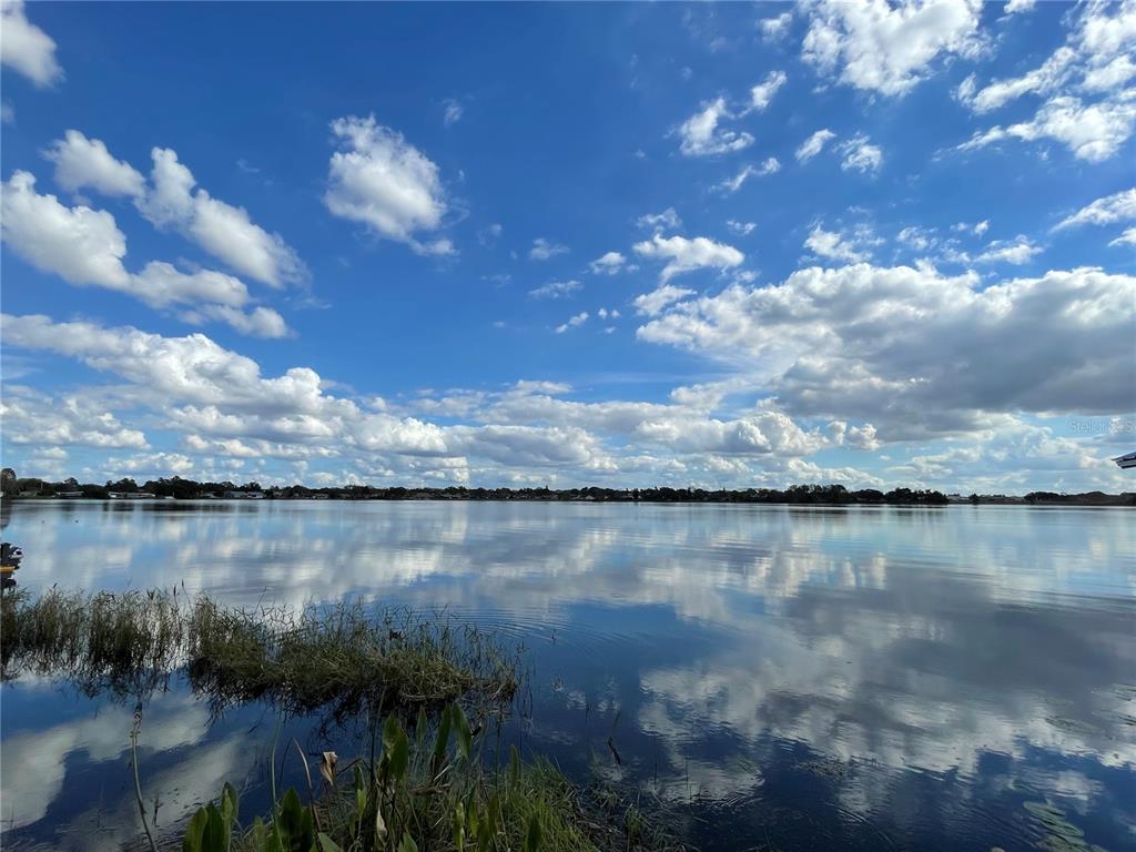 A view of a calm lake under a bright blue sky with scattered clouds — 687 LAKE DEXTER CIRCLE, WINTER HAVEN, FL