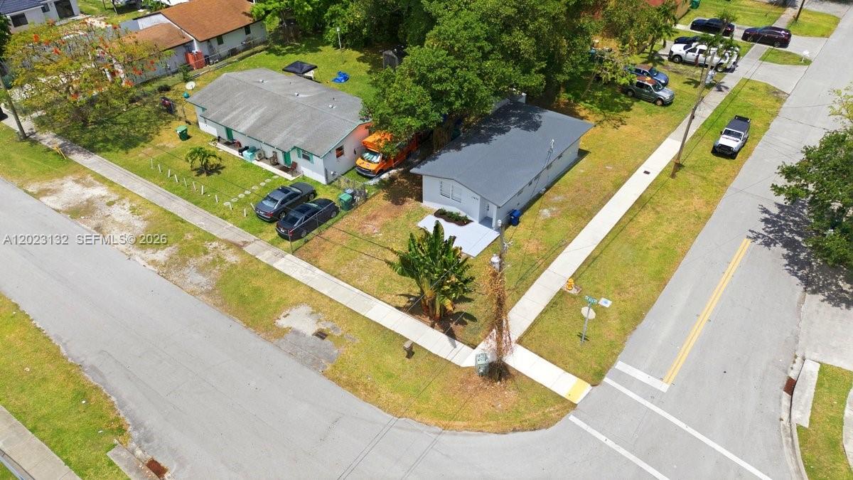 A small, white, single-story house sits on a grassy lot with a large palm tree — 17875 SW 103rd Ave, Miami FL 33157, MIAMI, FL