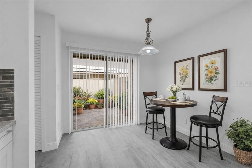 A dining area with a round table, two chairs, and a sliding glass door to a patio — 4402 RING NECK ROAD UNIT 19B, ORLANDO, FL