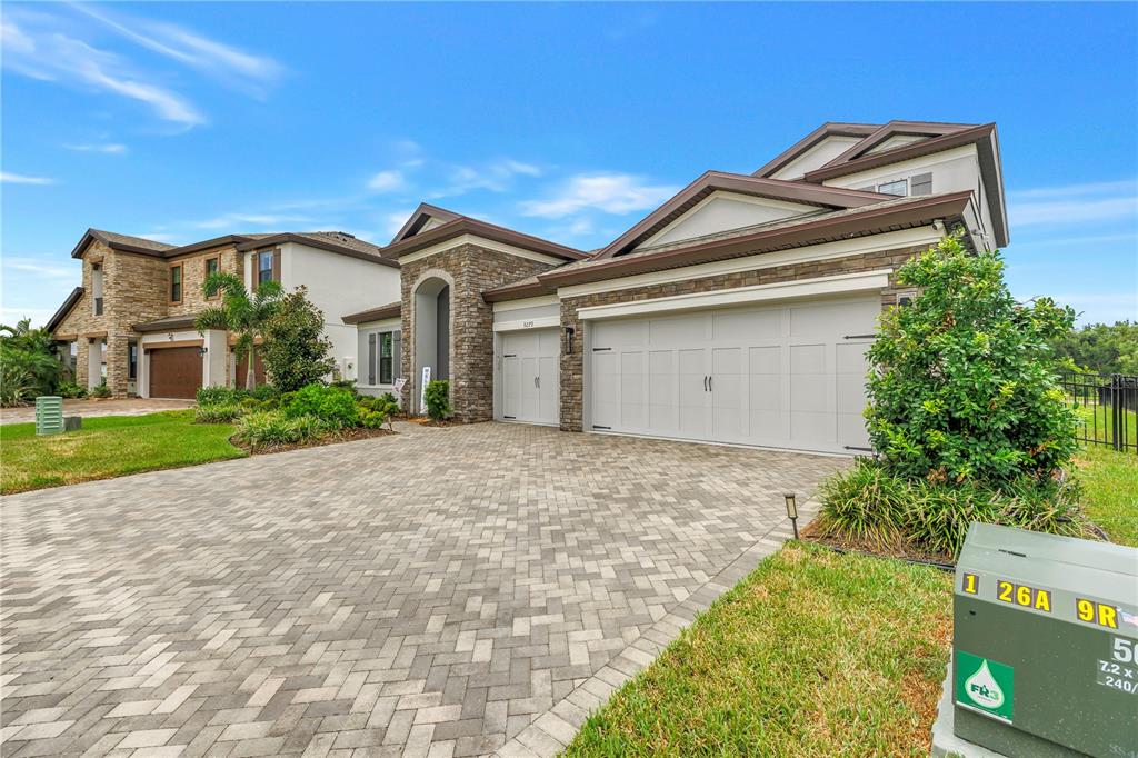 A covered entryway features a light blue double door, stone pillars, and a welcome sign — 9279 WARM SPRINGS CIRCLE, PARRISH, FL