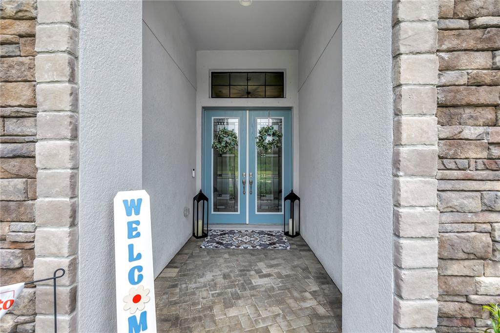 A hallway with wood-look flooring leads toward an open living area with a pool view — 9279 WARM SPRINGS CIRCLE, PARRISH, FL