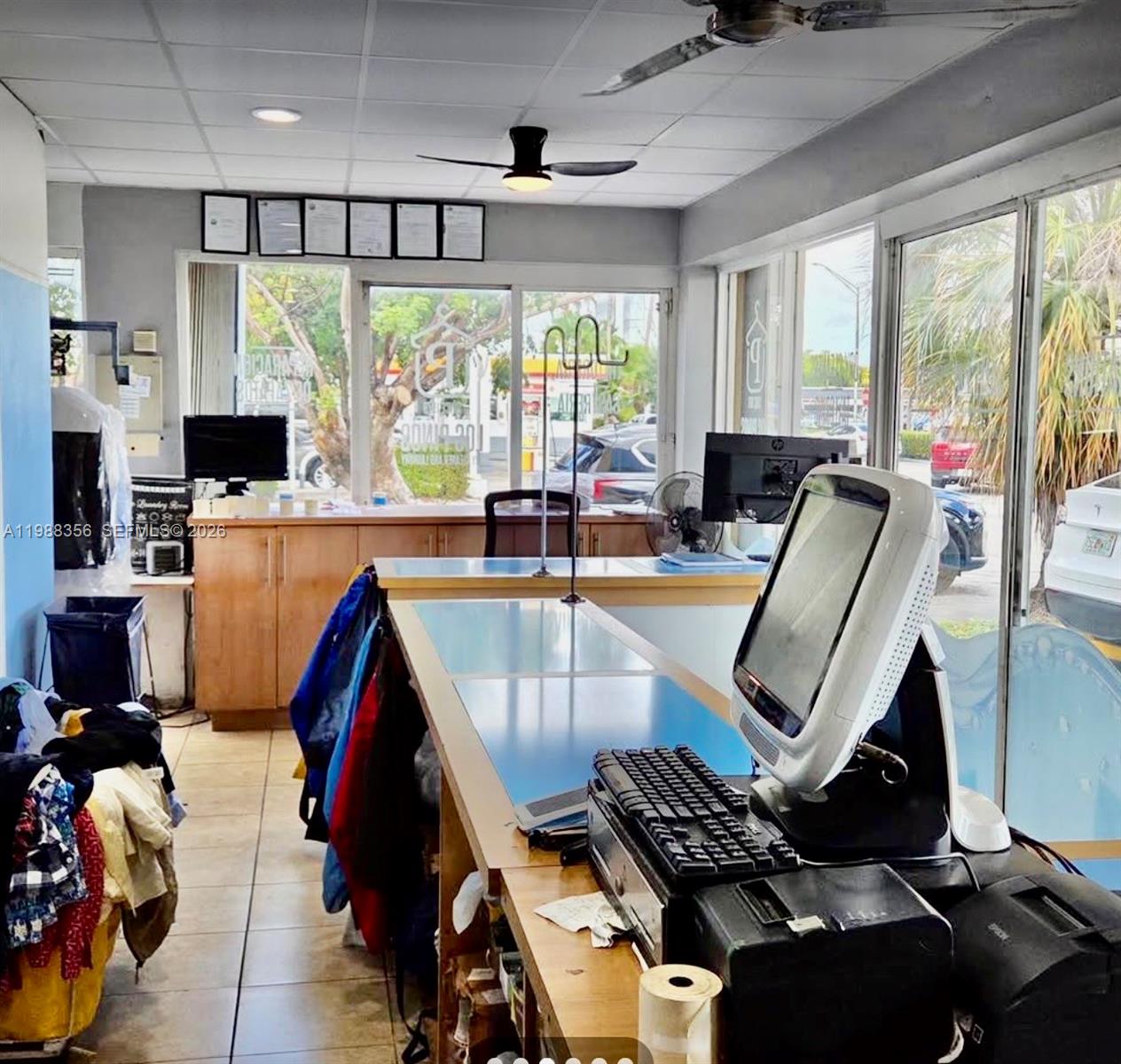 A dry cleaner front desk area features a computer, counter, and large windows looking outside — 4222 W 16th Ave, Hialeah FL 33012, HIALEAH, FL