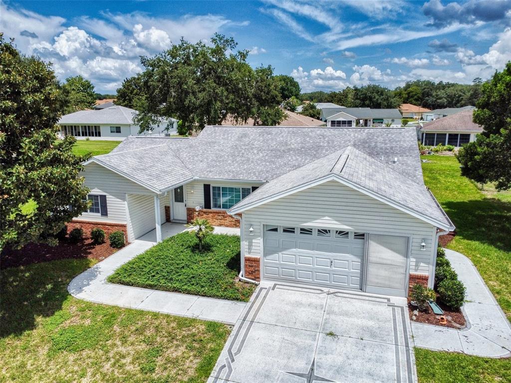 An aerial view of a single-story house with a gray shingled roof and garage — 13729 SE 89TH AVENUE, SUMMERFIELD, FL
