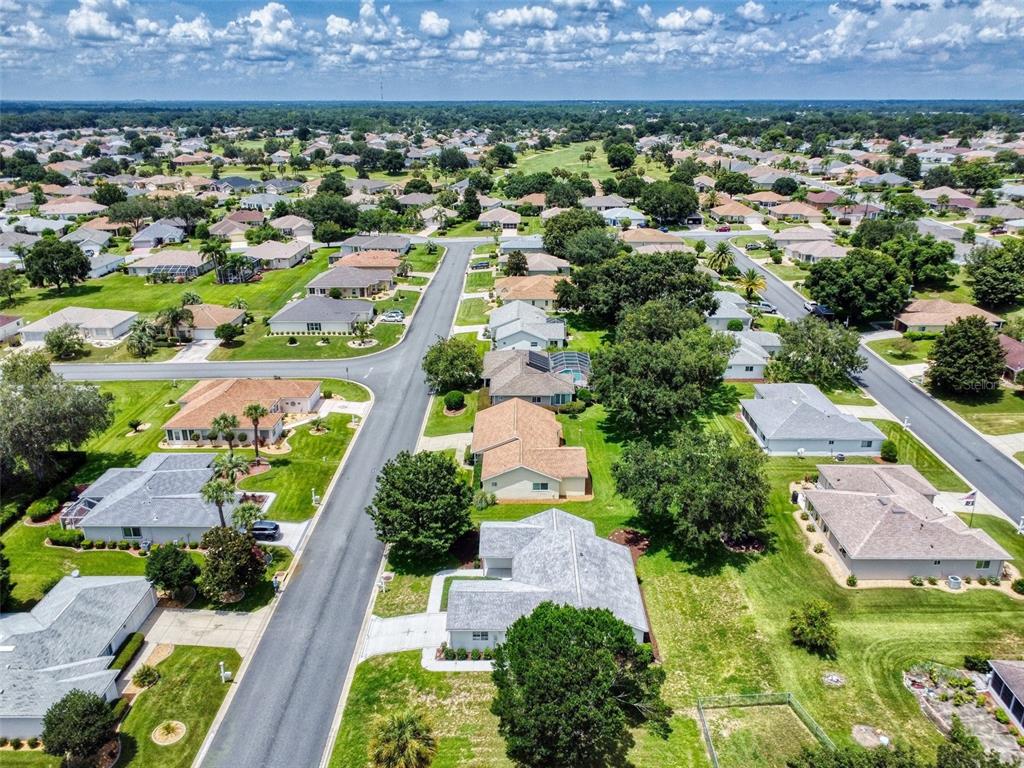 An aerial view of a suburban neighborhood with single-family homes, green lawns, and paved streets — 13729 SE 89TH AVENUE, SUMMERFIELD, FL