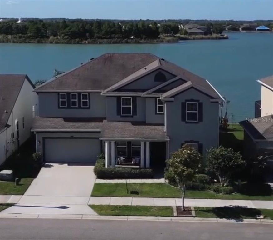 A two-story house with a gray exterior, a two-car garage, and a waterfront backyard — 417 BLUE CYPRESS DRIVE, GROVELAND, FL