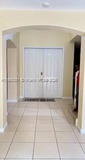 An entryway with a tiled floor and an arched opening leading to double front doors — 1906 SE 18th St, Homestead FL 33035, HOMESTEAD, FL