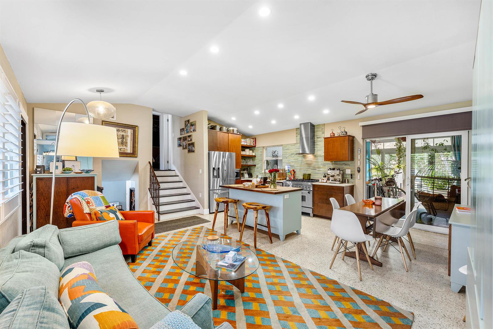 An open-concept living room and kitchen featuring a colorful rug, island, and dining area — 1455 NE 4th Avenue, Boca Raton FL 33432, BOCA RATON, FL