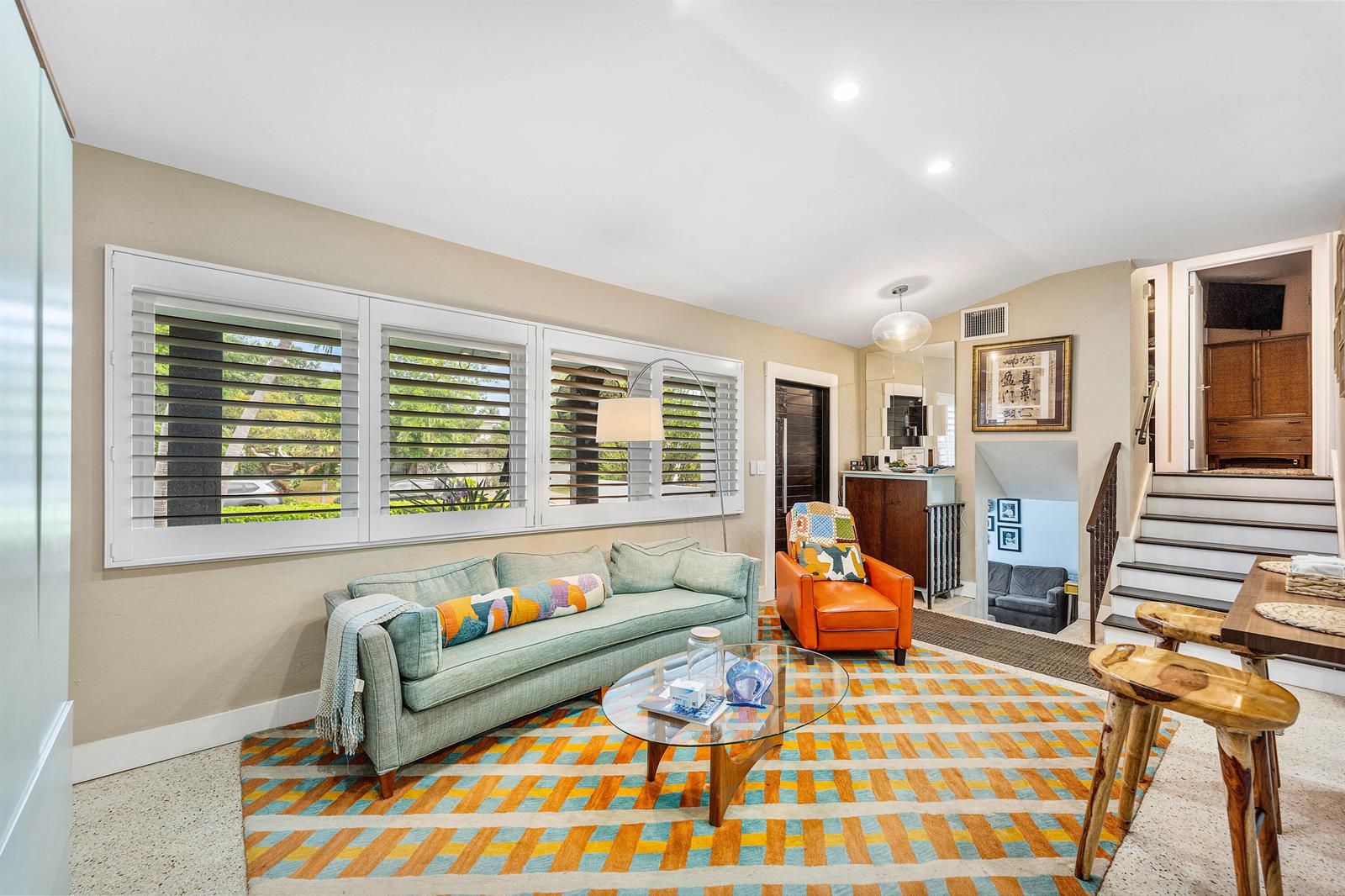 A living room features a teal sofa, orange armchair, glass coffee table, and patterned rug — 1455 NE 4th Avenue, Boca Raton FL 33432, BOCA RATON, FL