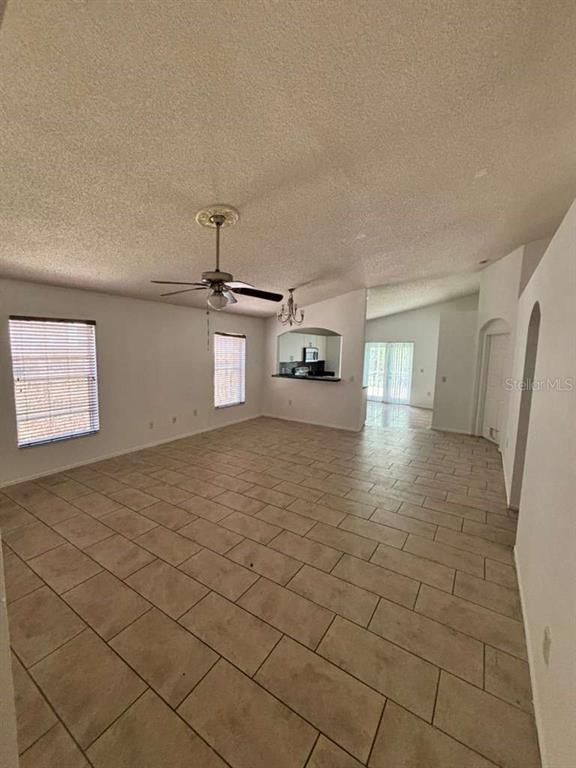 An open-concept living area features light-colored tile flooring, a ceiling fan, and a kitchen pass-through — 2713 PALM ISLE WAY, ORLANDO, FL