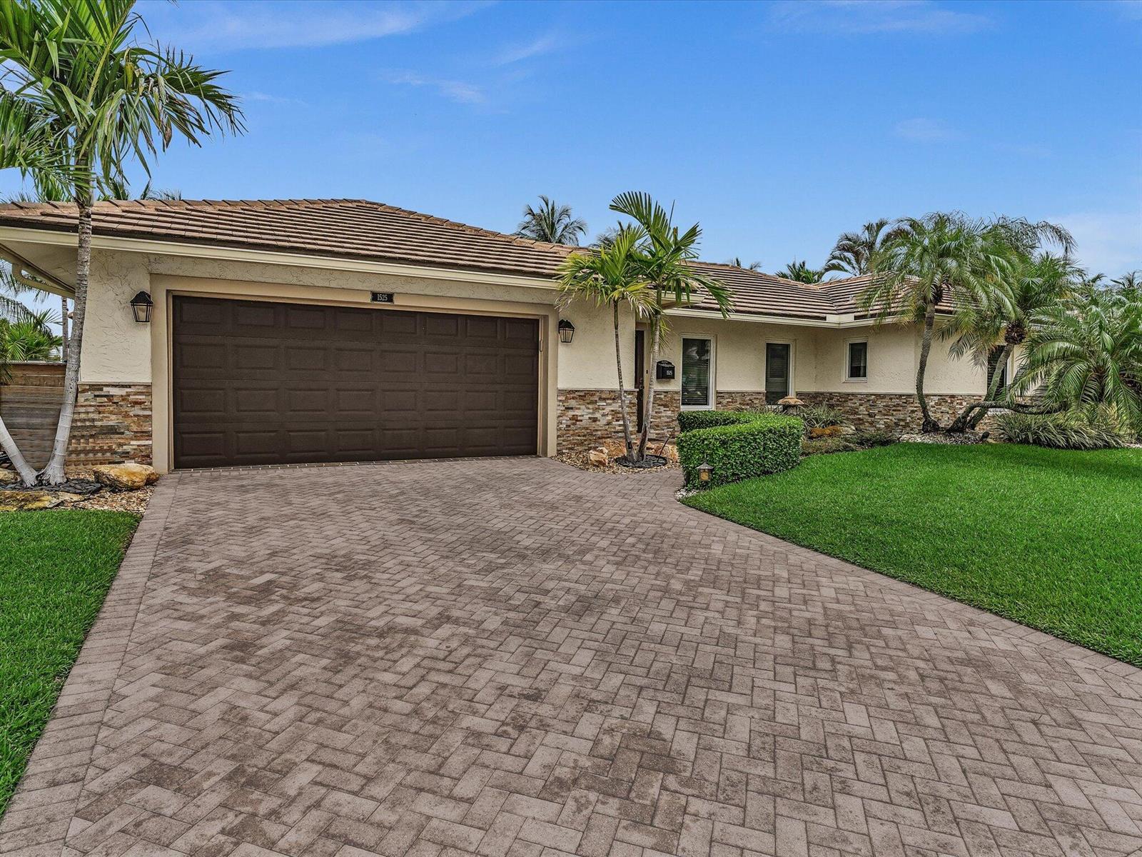 A single-story house with a paved driveway, stone veneer siding, and palm trees — 1525 SE 12th Street, Deerfield Beach FL 33441, DEERFIELD BEACH, FL