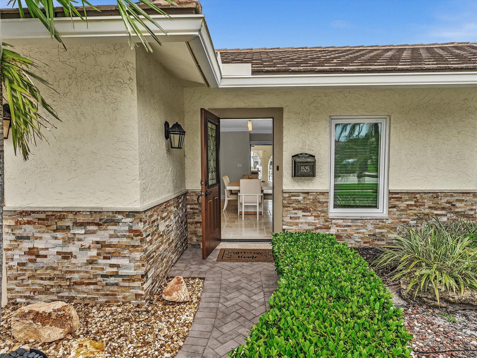 The front entrance features a stone-accented exterior, a paved walkway, and a hedge-lined garden — 1525 SE 12th Street, Deerfield Beach FL 33441, DEERFIELD BEACH, FL
