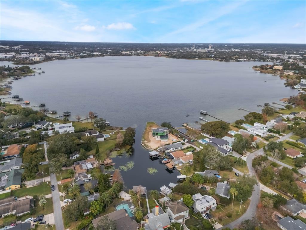 An aerial view shows a house under construction on a point extending into a lake — 1113 VENETIAN AVENUE, ORLANDO, FL