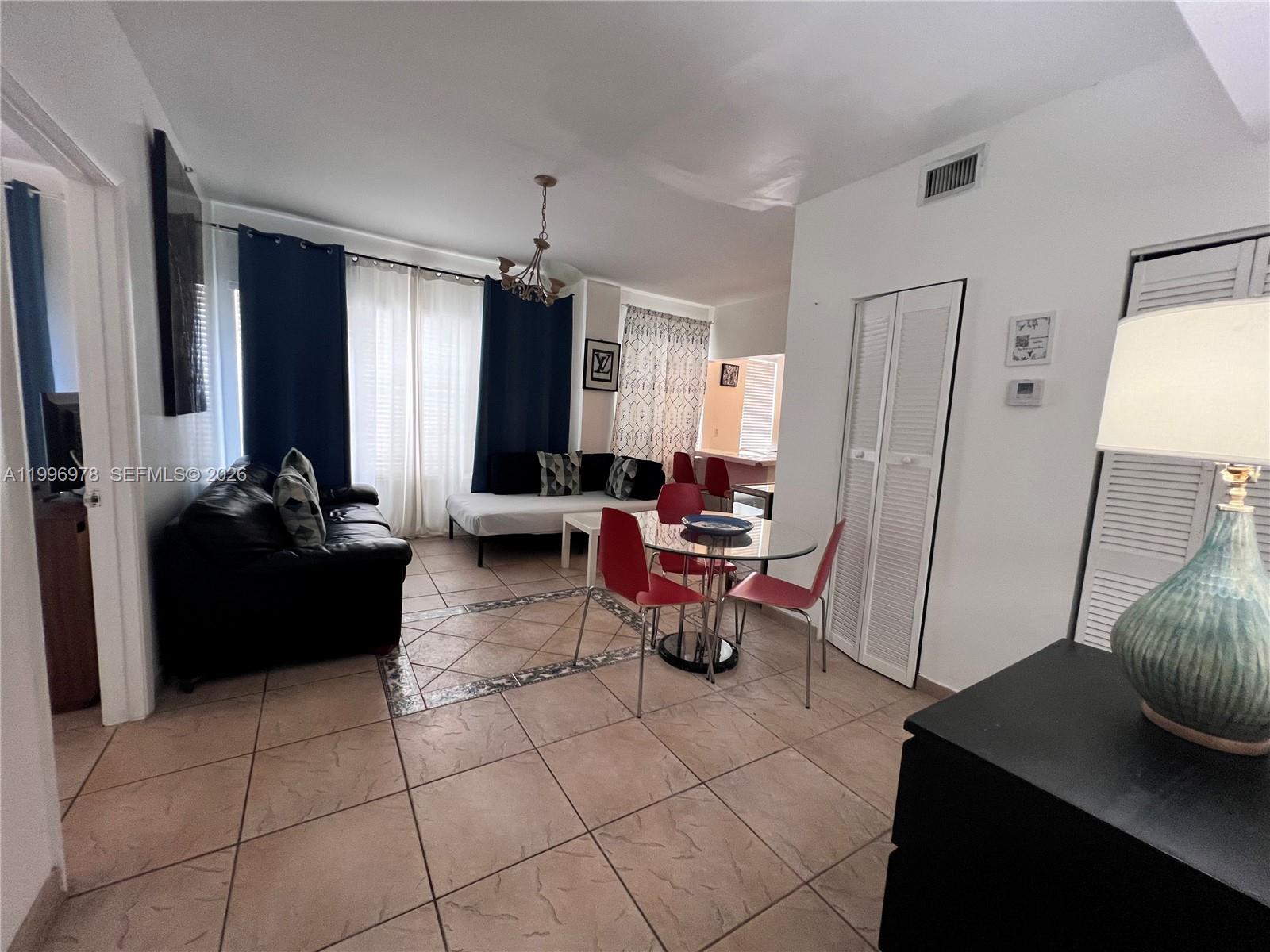 A living and dining area features tile floors, a glass-top table, and a dark sofa — 918 Ocean Dr # 302, Miami Beach FL 33139, MIAMI BEACH, FL