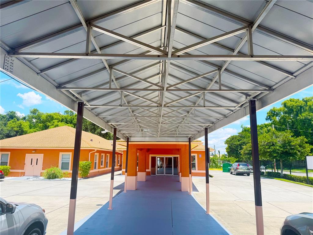 A covered walkway leads to the entrance of an orange building with a metal roof — 815 24TH STREET, ORLANDO, FL