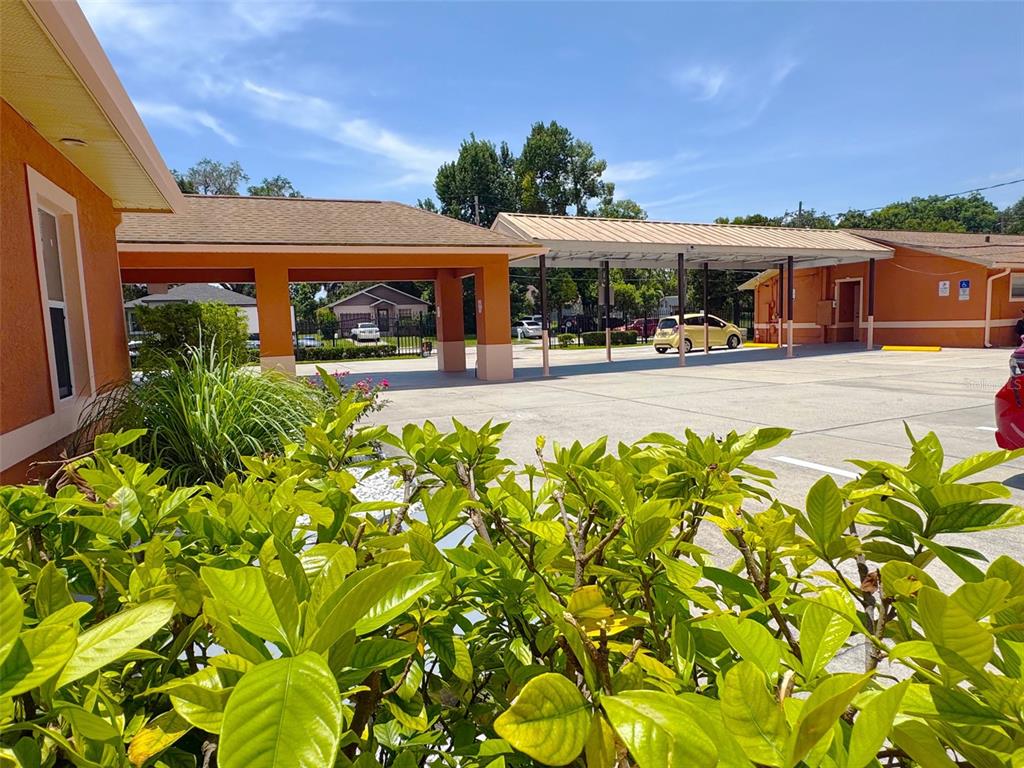 A parking lot with a covered carport area sits in front of a commercial building — 815 24TH STREET, ORLANDO, FL