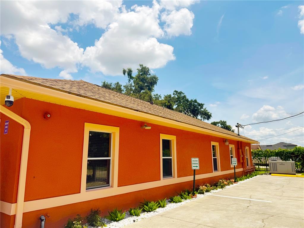 The exterior of a bright orange building features a shingled roof and visitor parking signs — 815 24TH STREET, ORLANDO, FL