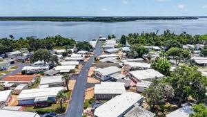 An aerial view shows a mobile home community situated along a large body of water — 3896 PICCIOLA UNIT 224, FRUITLAND PARK, FL