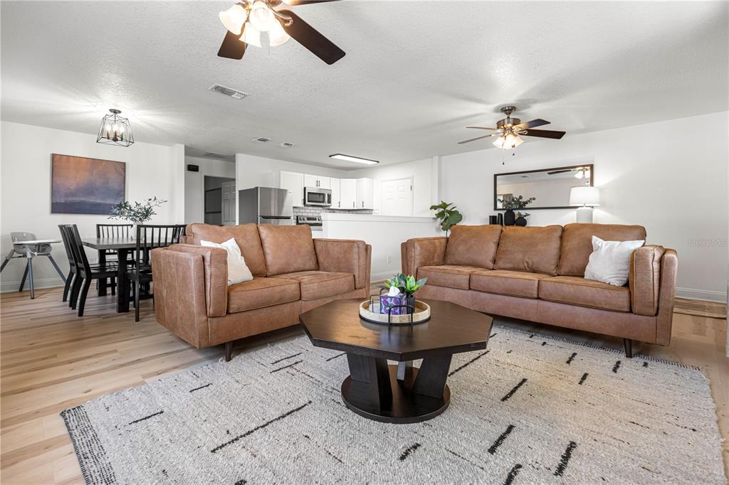 A living room with two brown leather sofas, a coffee table, and an adjacent dining area — 431 NW 60TH AVENUE, OCALA, FL
