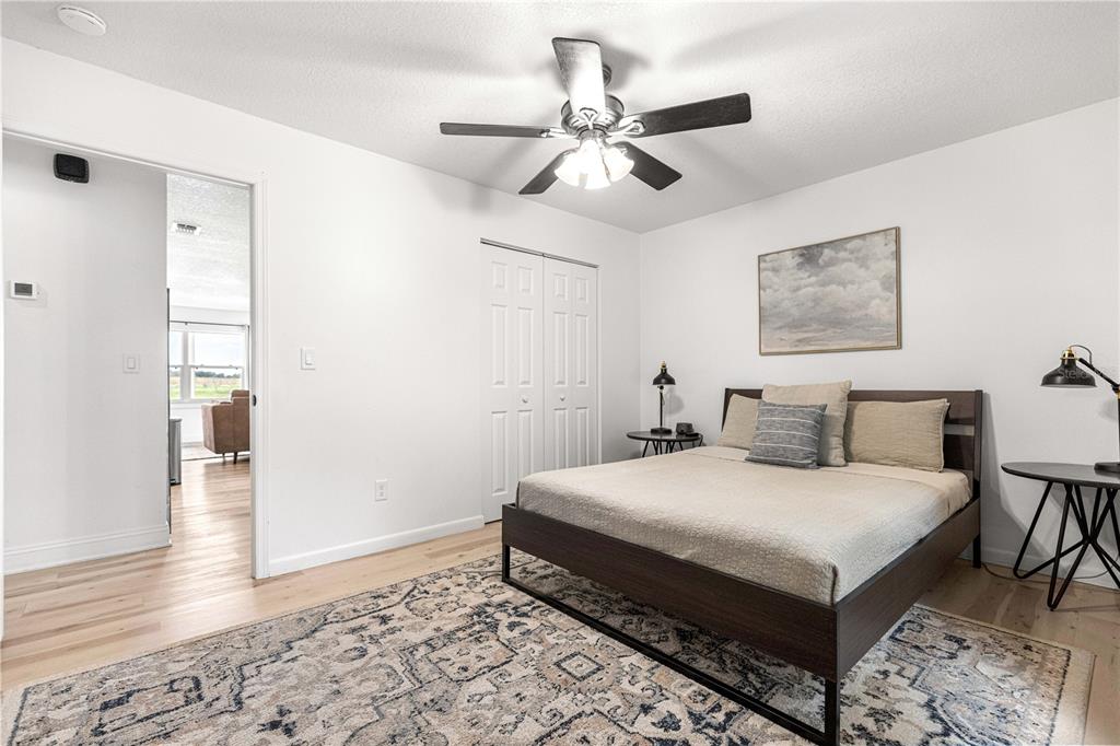 A bedroom features a bed, a ceiling fan, and a doorway leading to another room — 431 NW 60TH AVENUE, OCALA, FL