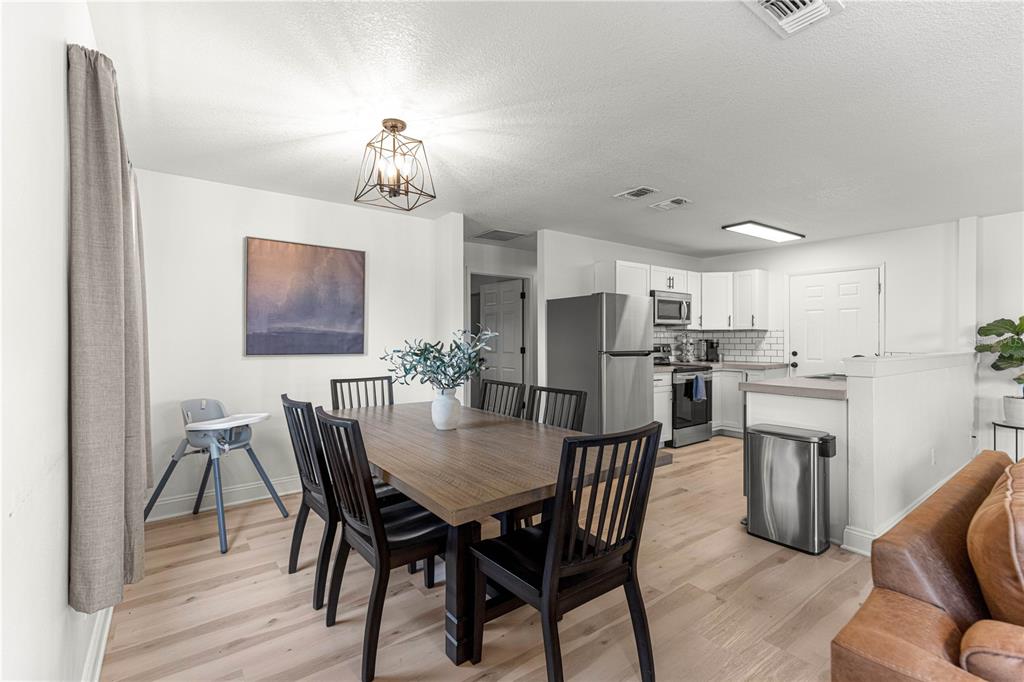 A dining area with a wooden table and chairs sits adjacent to an open kitchen — 431 NW 60TH AVENUE, OCALA, FL