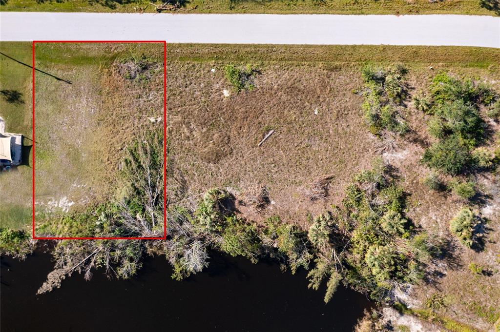 An aerial view shows a rectangular vacant lot outlined in red bordering a small lake — 9582 SALT LAKE STREET, PORT CHARLOTTE, FL