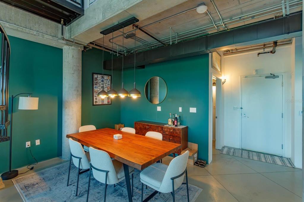 A dining area features a wooden table, four chairs, and a teal accent wall — 10 N SUMMERLIN AVENUE UNIT 55, ORLANDO, FL