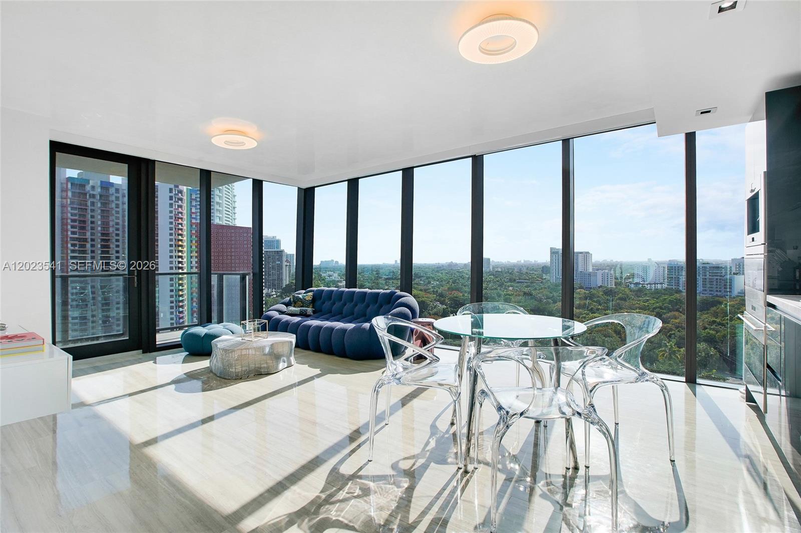A modern living and dining area features floor-to-ceiling windows, tile flooring, and city views — 1451 Brickell Ave # 1604, Miami FL 33131, MIAMI, FL