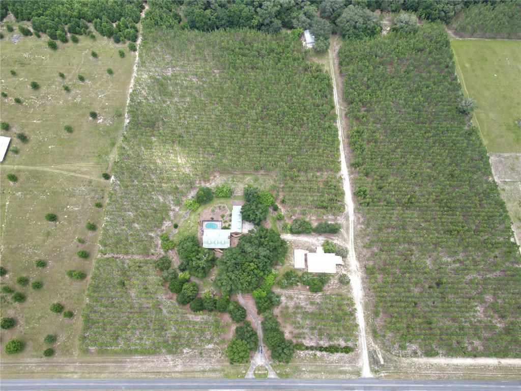 An aerial view shows a house with a pool surrounded by trees and open fields — 272 NE COUNTY ROAD 337, TRENTON, FL