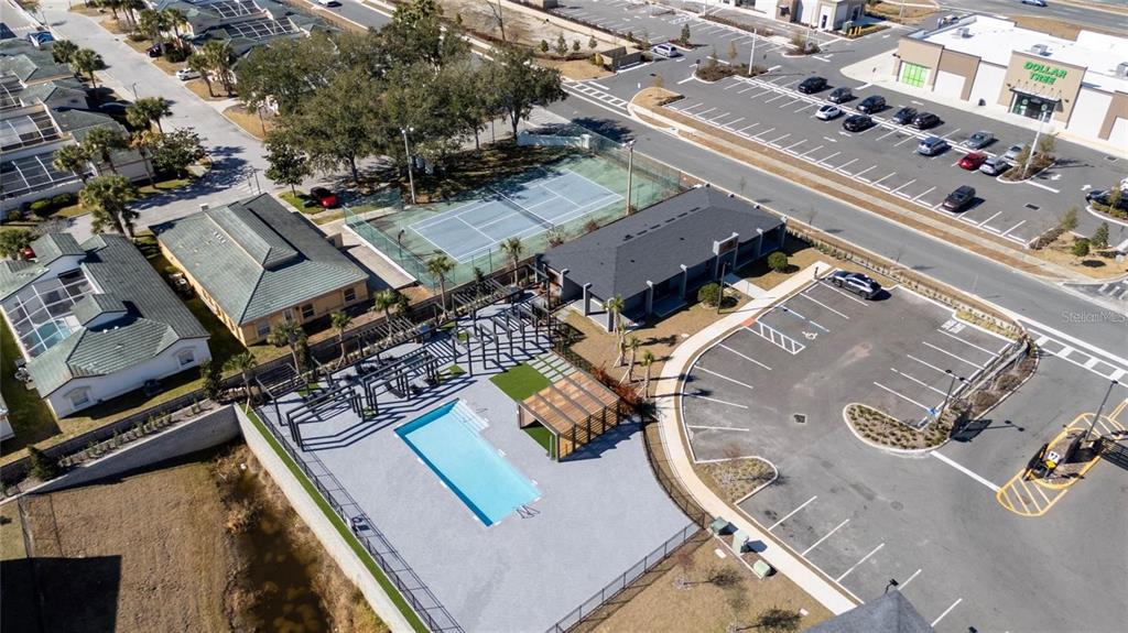 An aerial view shows a community pool, tennis court, clubhouse, and adjacent parking lot — 3243 SUSTAINABLE WAY, KISSIMMEE, FL