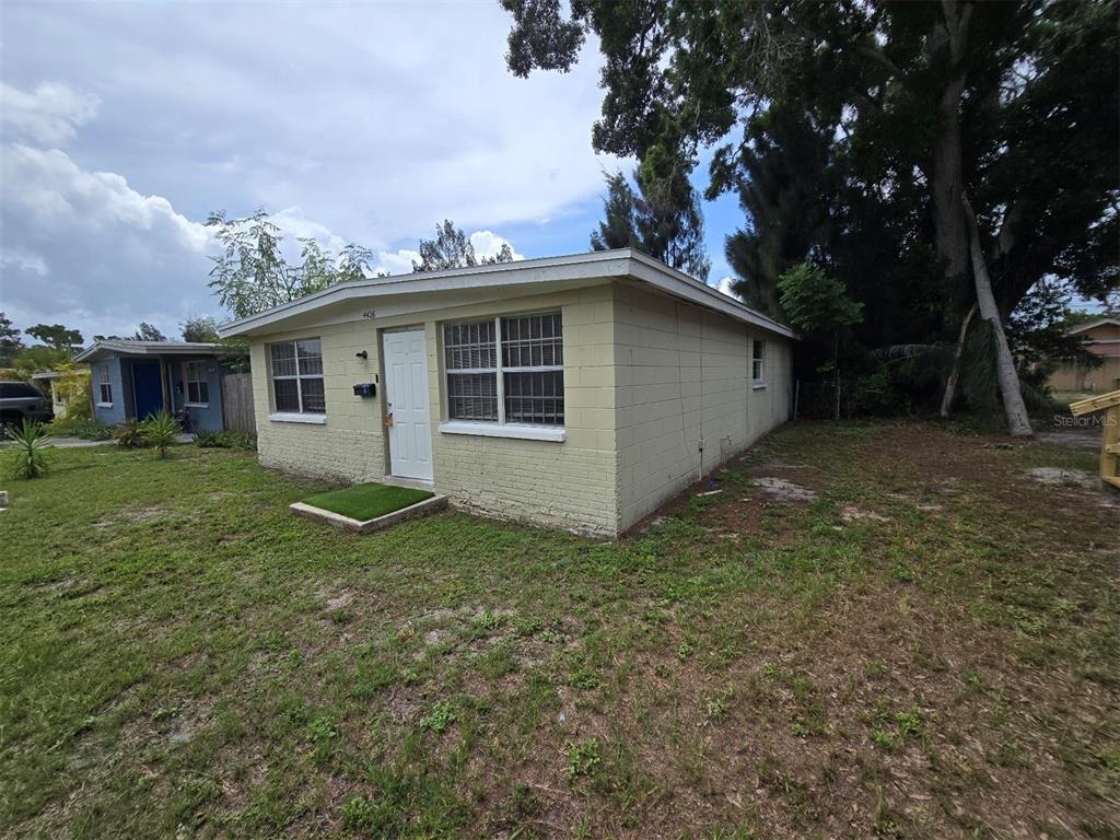 A single-story, light-colored concrete block house with a flat roof and a small front yard — 4426 13TH AVENUE S, ST PETERSBURG, FL