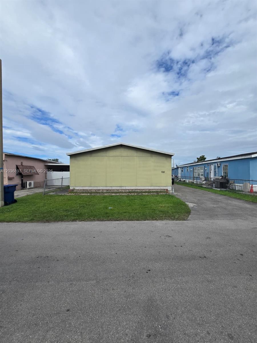 A single-story mobile home with a light green exterior sits on a grassy lot — 1061 SW 131 PL, Miami FL 33184, MIAMI, FL