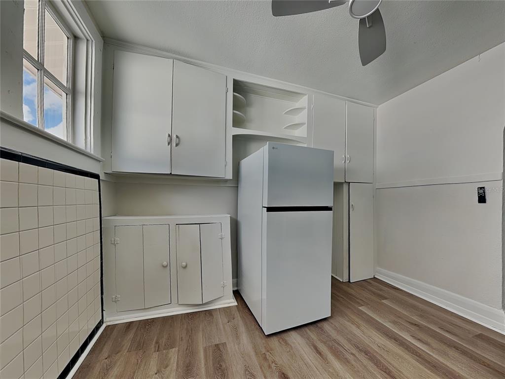 A kitchen features white cabinetry, a white refrigerator, and wood-look flooring — 2904 W CHESTNUT STREET UNIT 2, TAMPA, FL