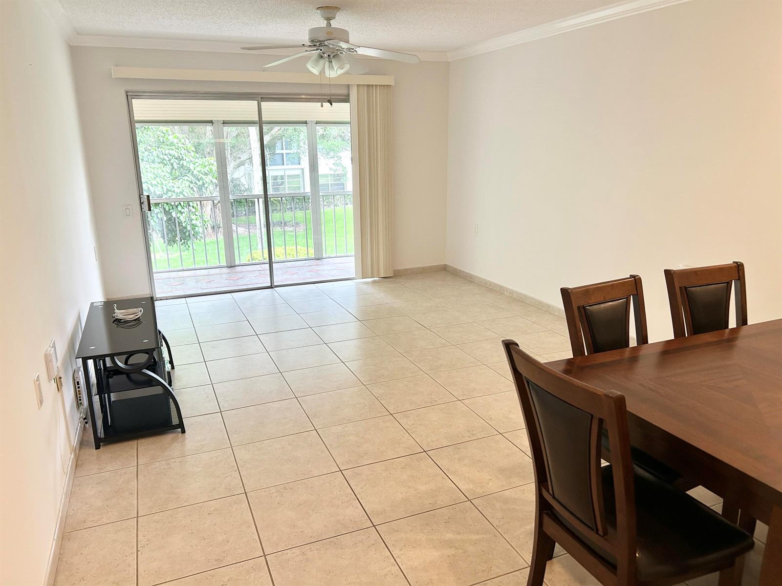A dining area and living space with tile floors, a ceiling fan, and sliding glass doors — 2613 Nassau Bend # C2, Coconut Creek FL 33066, COCONUT CREEK, FL