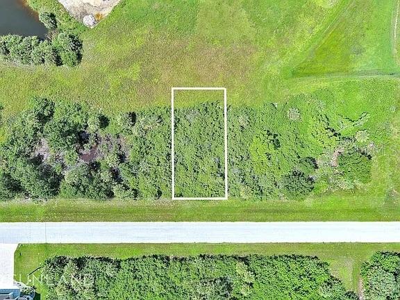 An aerial view shows a rectangular plot of land outlined in white near a road — 316 SUNSET ROAD, ROTONDA WEST, FL