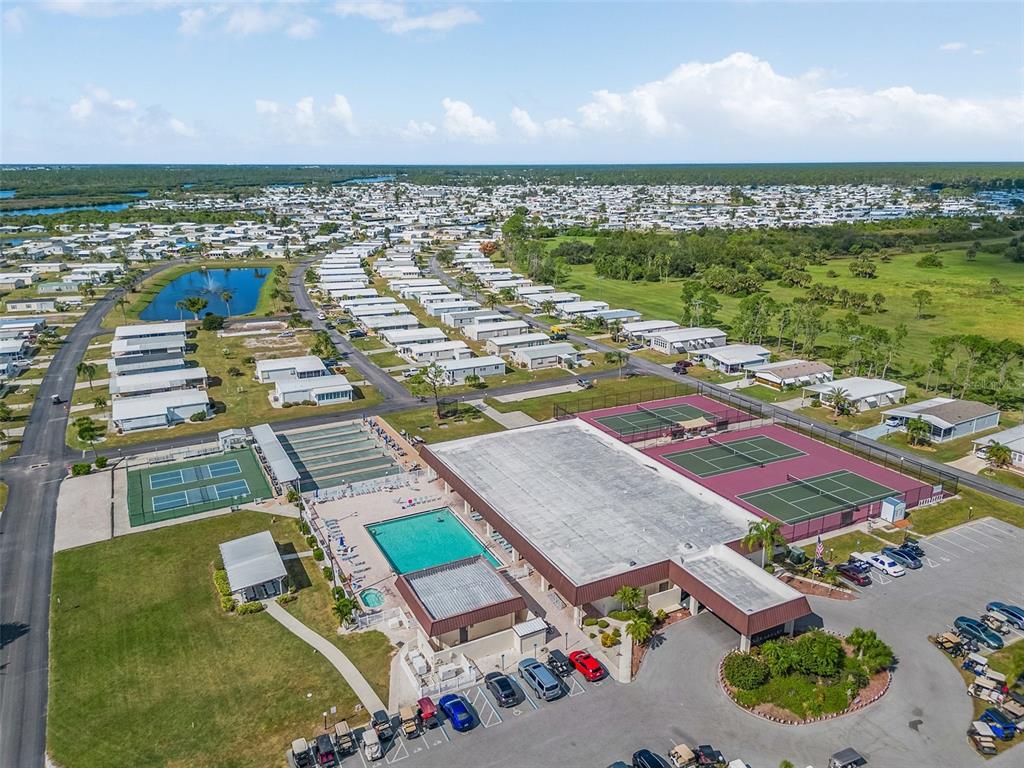 An aerial view shows a community clubhouse with a swimming pool and tennis courts — 502 SAN CLEMENTE CIRCLE, NORTH PORT, FL