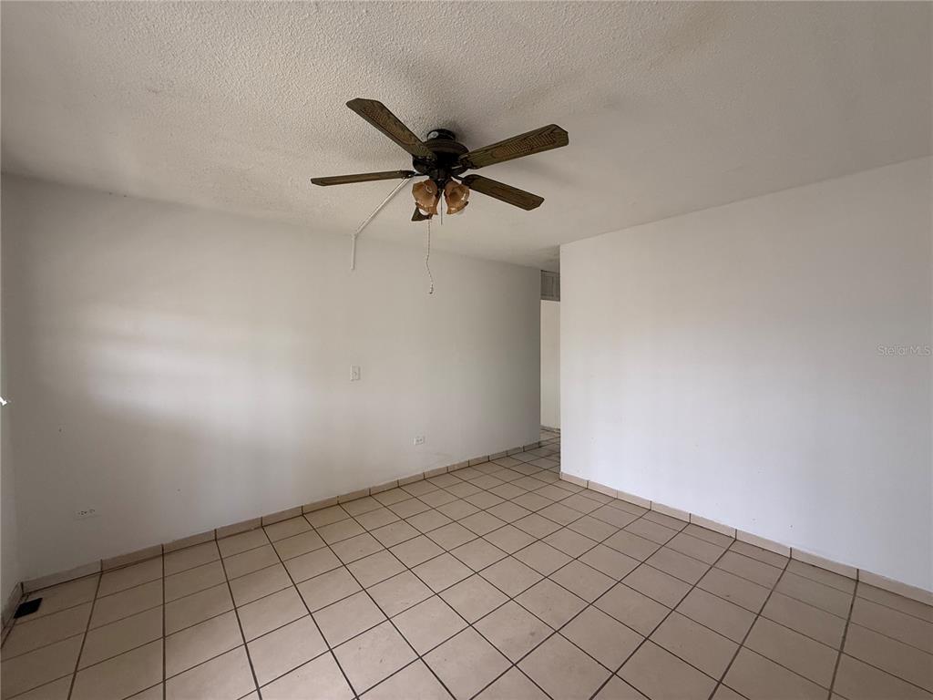 An empty room with white walls, a ceiling fan, and light-colored square floor tiles — 20 ST VILLA NUEVA UNIT W-41, CAGUAS, PR