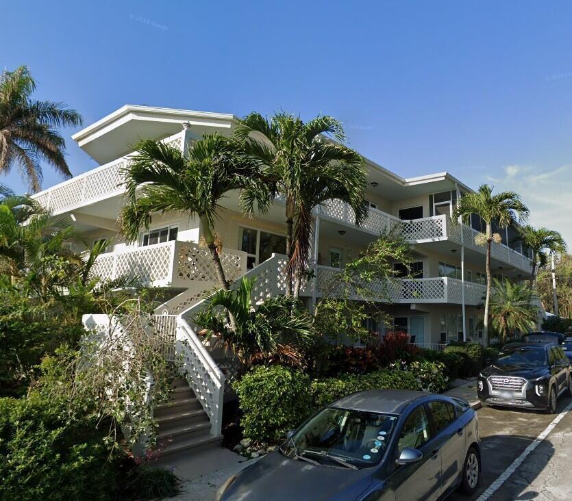 A multi-story apartment building with white lattice balconies, exterior stairs, and palm trees — 131 N Golfview Road # 4, Lake Worth FL 33460, LAKE WORTH, FL