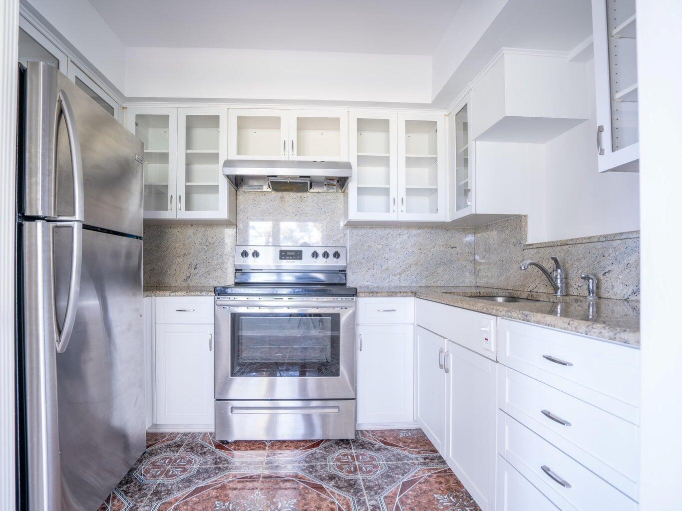 A kitchen with white cabinets, stainless steel appliances, granite countertops, and patterned tile flooring — 131 N Golfview Road # 4, Lake Worth FL 33460, LAKE WORTH, FL