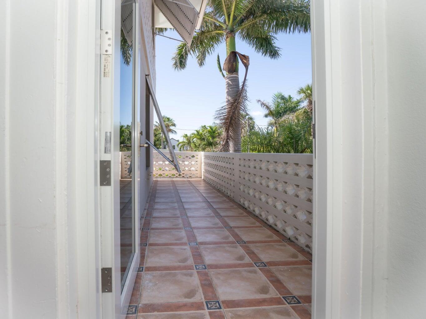 A view from a doorway onto a tiled balcony with a decorative concrete block railing — 131 N Golfview Road # 4, Lake Worth FL 33460, LAKE WORTH, FL