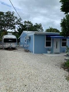 A light blue house with a white door and an Airstream trailer parked alongside — 919 Lobster Ln # 0, Key Largo FL 33037, KEY LARGO, FL