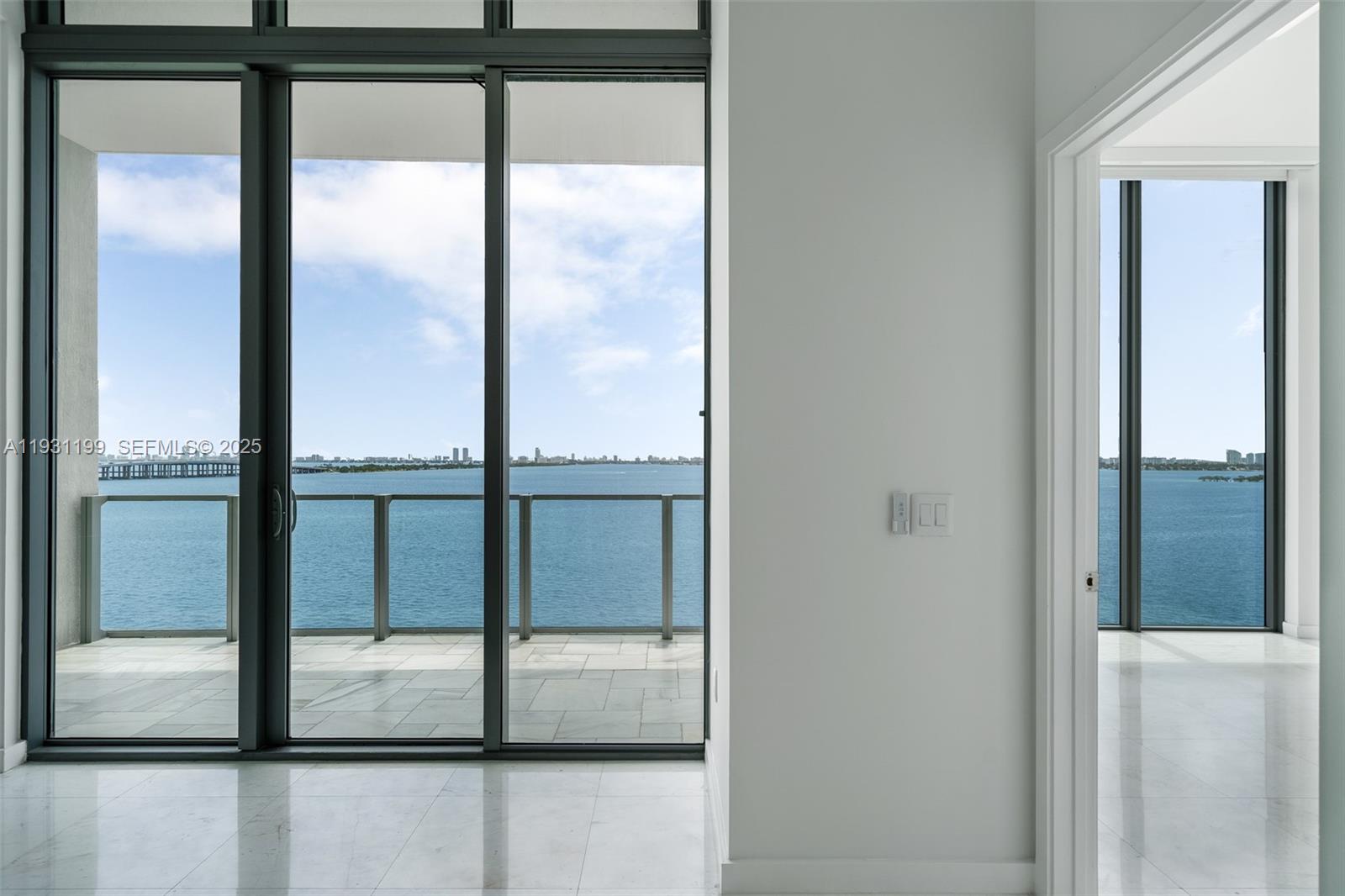 A bright room with white marble floors, floor-to-ceiling windows, and a balcony overlooking water — 2900 NE 7th Ave # 604, Miami FL 33137, MIAMI, FL