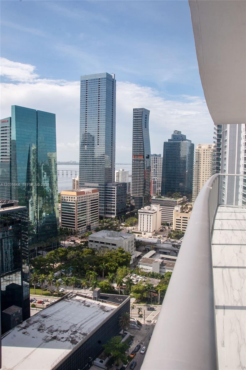 A high-angle view from a balcony overlooking a dense urban skyline with multiple skyscrapers — 1100 S MIAMI AV # 4001, Miami FL 33130, MIAMI, FL