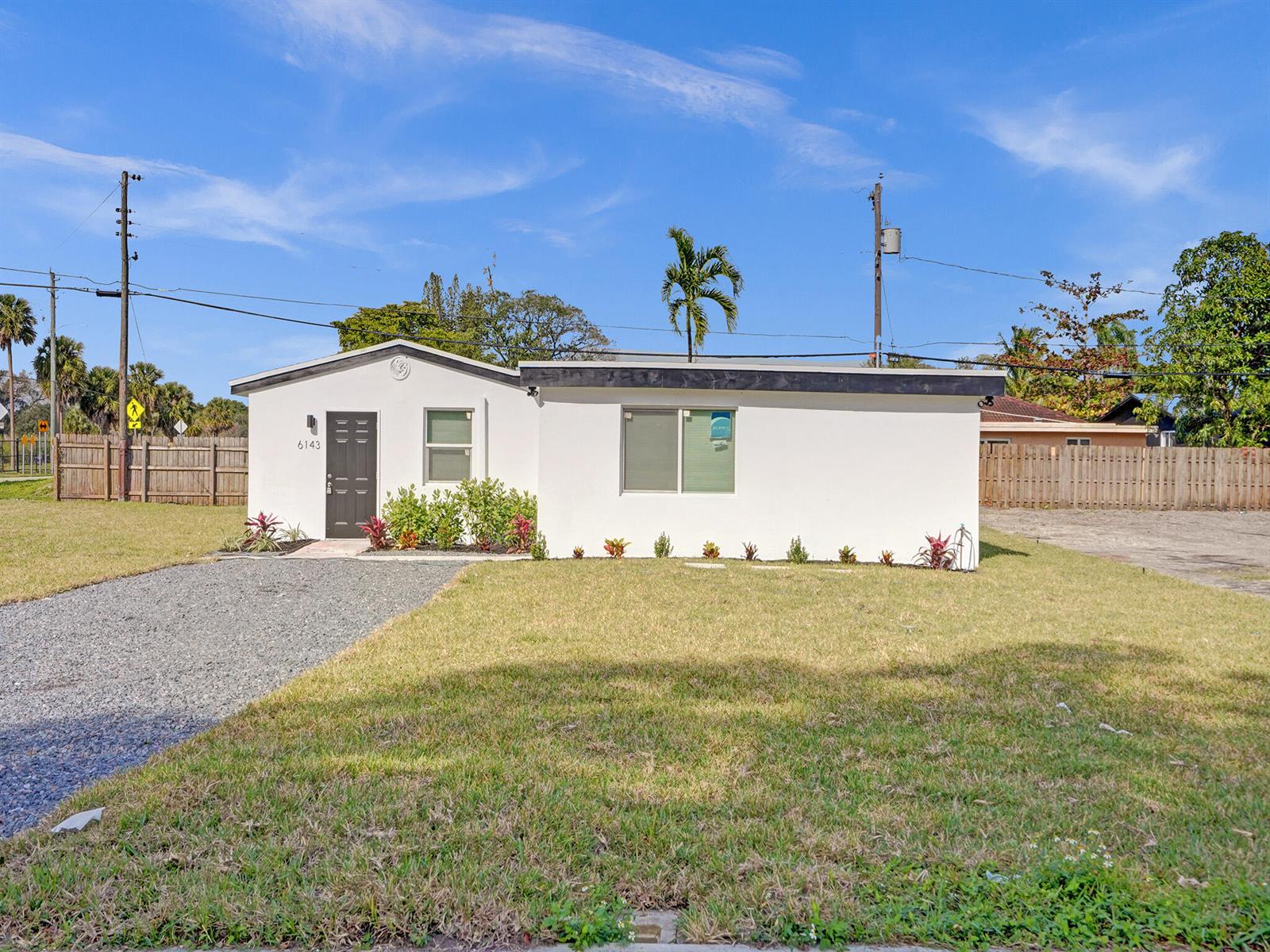 A single-story white house with a gravel driveway and a small front lawn — 6143 SW 40th Street, Miramar FL 33023, MIRAMAR, FL