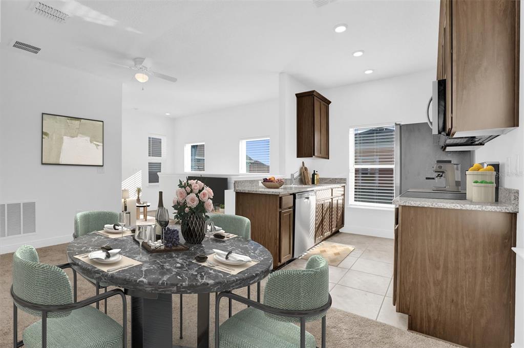 This is a digital rendering of a dining area adjacent to a kitchen with wood cabinets — 3008 MIRAGE PLACE, ST CLOUD, FL