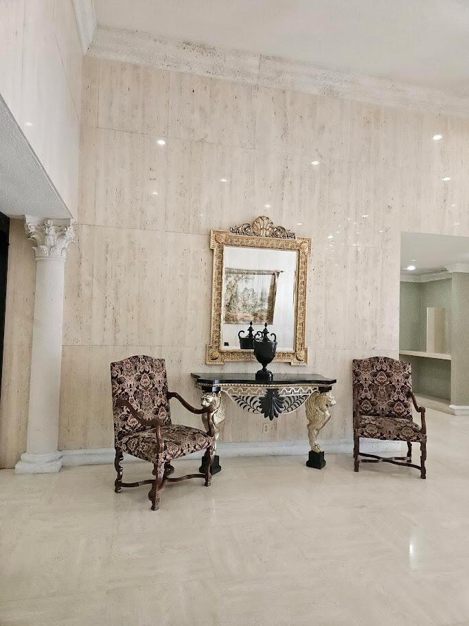 A modern kitchen features white cabinets, marble-patterned countertops, stainless steel appliances, and three pendant lights — 600 Three Islands Boulevard # 620, Hallandale Beach FL 33009, HALLANDALE BEACH, FL