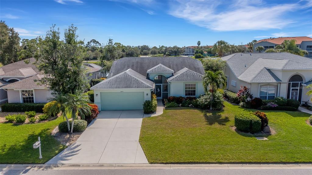 A single-story house with a light green garage door and a gray shingled roof — 8976 WHITEMARSH AVENUE, SARASOTA, FL