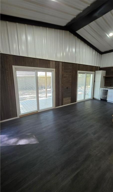 A room with dark wood-paneled walls, dark flooring, and two sliding glass doors leading outside — 401 SW KEMP COURT UNIT Suite B, LAKE CITY, FL