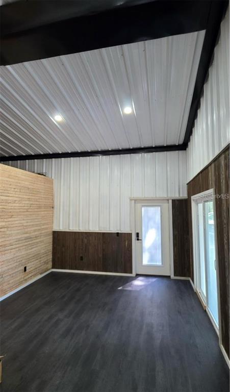An interior room features white metal walls and ceiling, dark wood paneling, and dark flooring — 401 SW KEMP COURT UNIT Suite B, LAKE CITY, FL