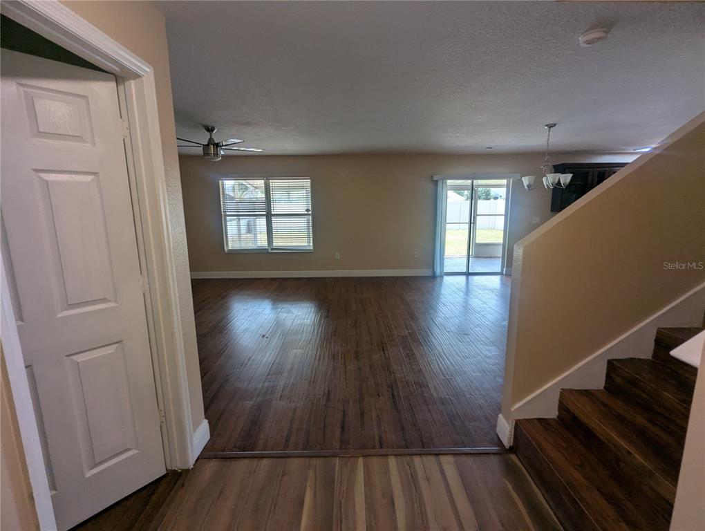 A view from a doorway looking into a living area with wood-look flooring and stairs — 1628 STRTHMORE CIRCLE, MOUNT DORA, FL